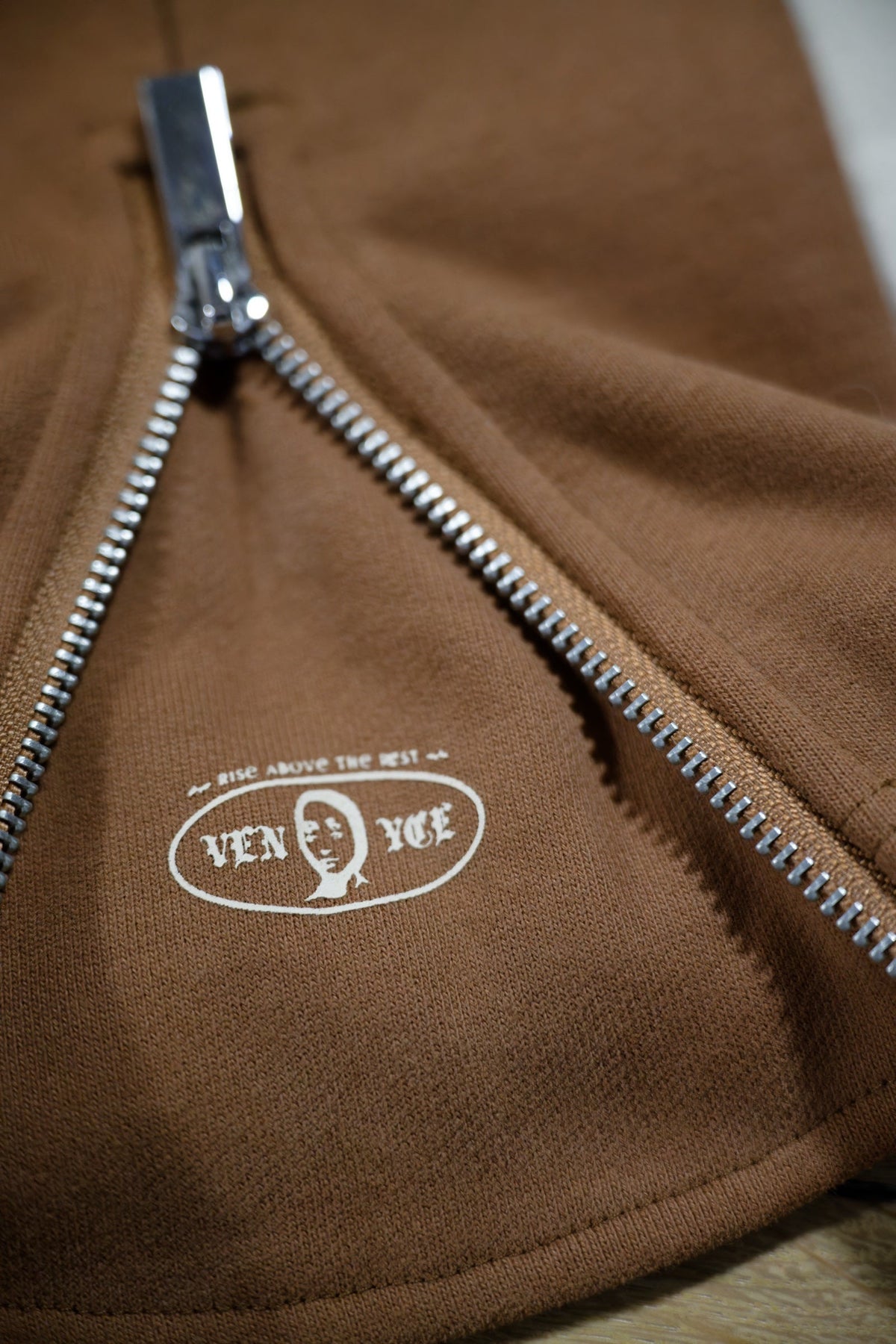 Jogging coton bi-color VENYCE — détail du zip de cheville et patch brodé Rise Above The Rest